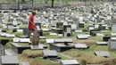  Petugas melintas di antara makam di TPU Tanah Kusir, Jakarta, Selasa (29/8). Sudin Kehutanan DKI Jakarta berencana memperluas area TPU Tanah Kusir. Perluasan dilakukan karena kebutuhan lahan pemakaman sangat tinggi. (Liputan6.com/Helmi Fithriansyah)