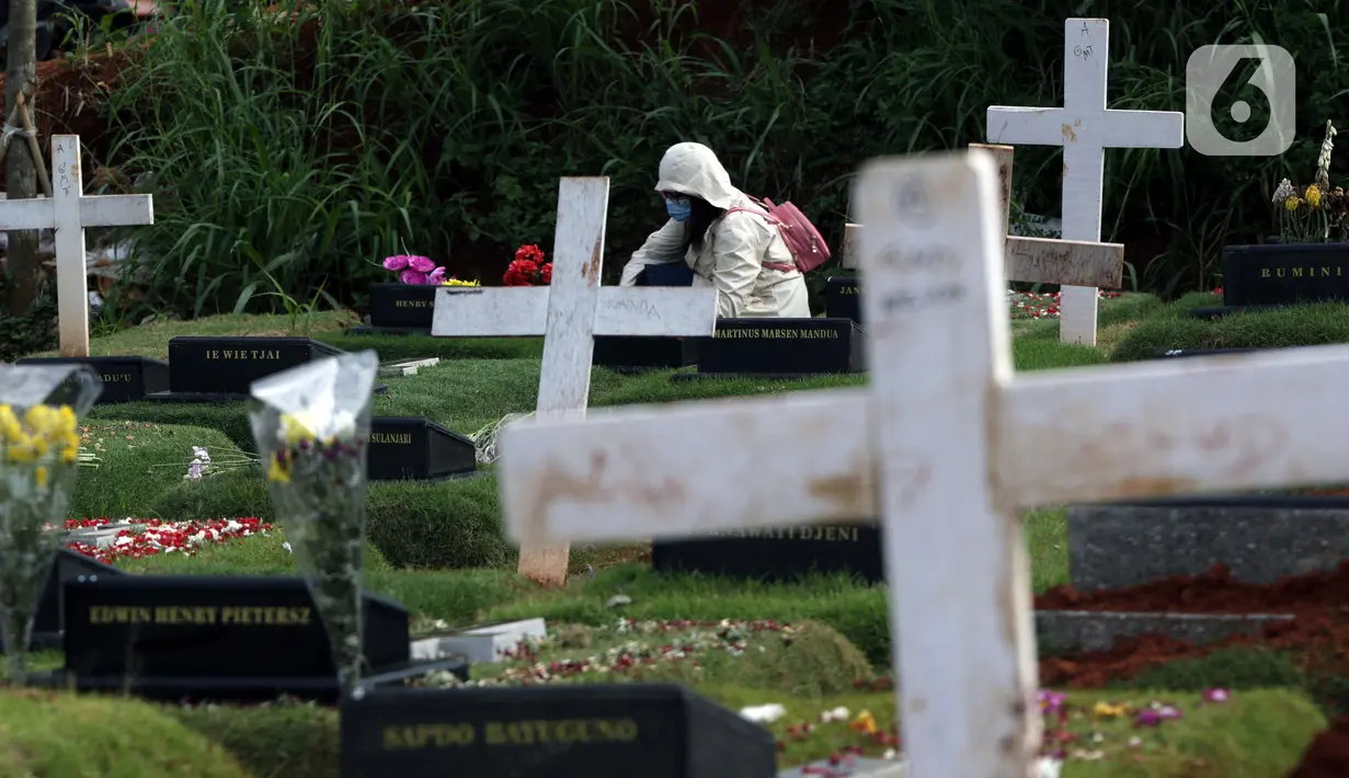 Warga melakukan ziarah di area pemakaman khusus dengan protokol COVID-19 di TPU Pondok Ranggon, Jakarta, Jumat (25/12/2020). Momen perayaan Natal 2020 dimanfaatkan sejumlah umat kristiani untuk berziarah mendoakan kerabat yang dimakamkan dengan protokol COVID-19. (Liputan6.com/Helmi Fithriansyah)