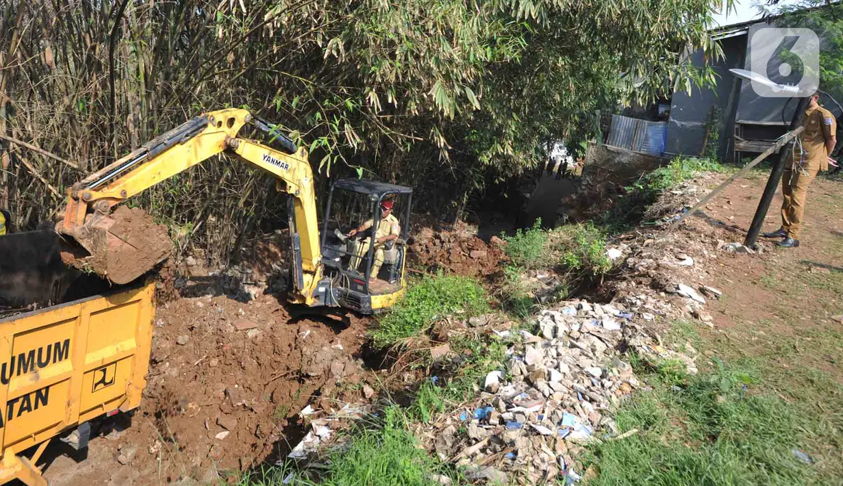 Petugas menggunakan alat berat backhoe membersihan jalan dari longsoran tanah di RT 04/RW 03, Kademangan, Keranggan, Setu, Tangerang Selatan, Banten, Selasa (3/12/2019). Longsor pada Senin sore kemarin menewaskan seorang pengendara sepeda motor yang melintas, Anggi (23). (merdeka.com/Arie Basuki)