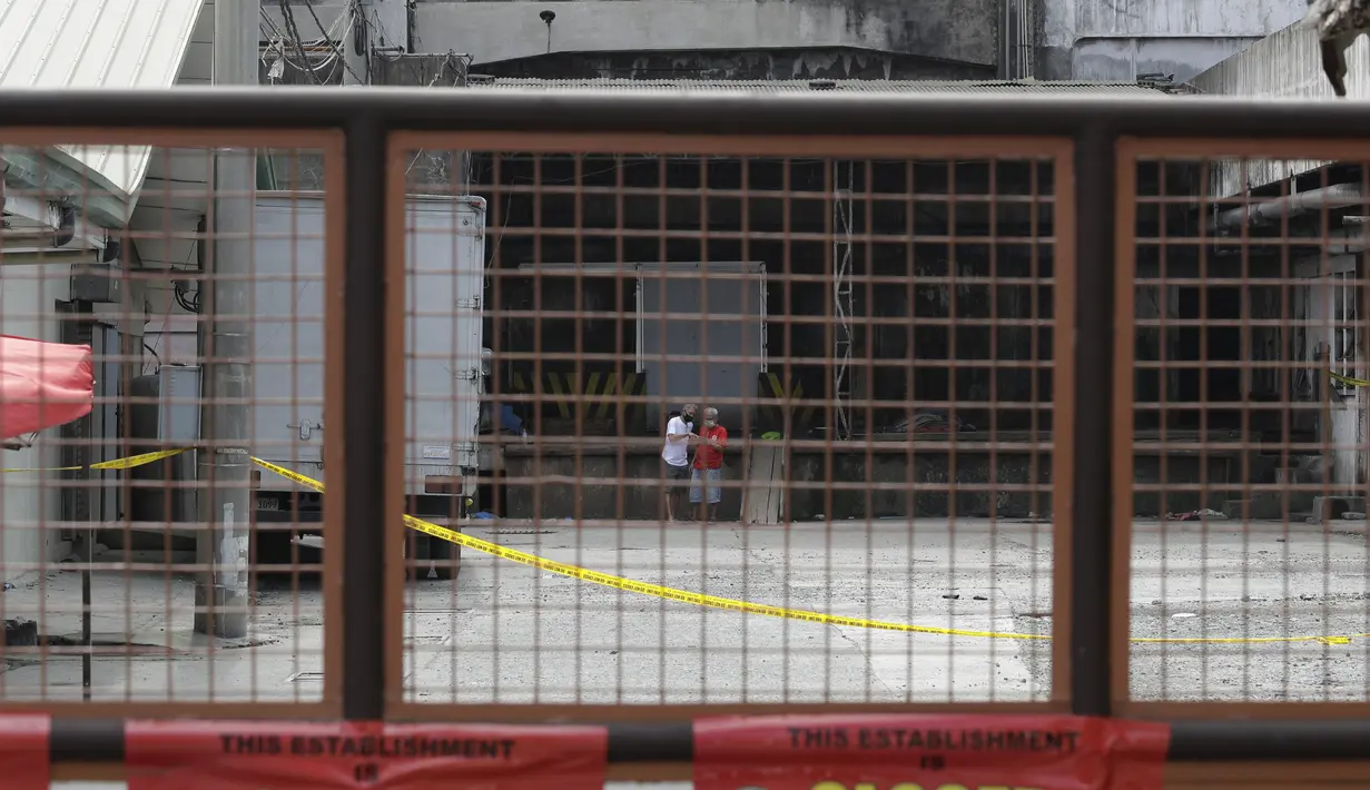 Dua pria berdiskusi di dalam kompleks Pabrik Es TP Marcelo di Navotas, Filipina, Kamis (4/2/2021). Kebocoran gas amonia terjadi di sebuah pabrik es di wilayah Manila, ibu kota Filipina. Kejadian itu menewaskan dua orang dan lebih dari 90 lainnya terluka atau jatuh sakit. (AP Photo/ Aaron Favila)
