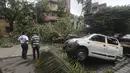 Sebuah mobil berdiri rusak dengan pohon tumbang setelah hujan lebat akibat siklon Tauktae di Mumbai India, pada Selasa (18/5/2021). Topan Tauktae disebut yang terbesar melanda wilayah itu dalam beberapa dekade terakhir.  (AP Photo/Rafiq Maqbool)