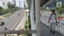 Pejalan kaki melintasi jembatan penyeberangan orang (JPO) di Ibu Kota Jakarta, Selasa (24/12/2019). Libur Natal dan Tahun Baru membuat kondisi lalu lintas di Jakarta lengang. (Liputan6.com/Angga Yuniar)