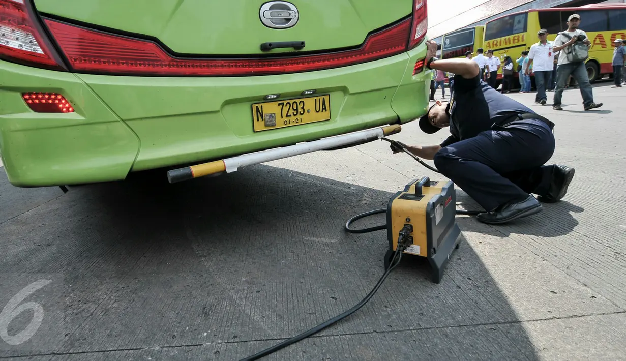 Petugas melakukan uji emisi bus yang akan digunakan untuk armada Lebaran di Terminal Kampung Rambutan, Jakarta, Jumat (24/6). Dishub DKI melakukan tes kesehatan pengemudi dan pengecekan bus jelang arus mudik 2016. (Liputan6.com/Yoppy Renato)