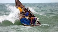 Sebuah perahu nelayan tradisional mencoba menembus gelombang di kawasan laut penghubung pantai Selat Malaka Lhokseumawe Propinsi Aceh. (ANTARA)