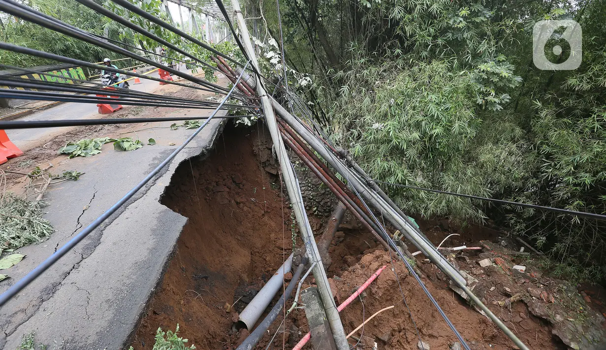 Kondisi longsor di kawasan Jembatan Darul Qur’an, Jalan KH. Tb. M. Falak, Kecamatan Bogor Barat, Kota Bogor, Jawa Barat, Rabu (12/10/2022). Longsor yang terjadi pada kemarin sore saat hujan deras menyebabkan jalan utama yang menghubungkan Jalan Semeru dengan Jalan Raya Loji-Gunung Batu kini hanya dapat dilalui sepeda motor. (merdeka.com/Arie Basuki)