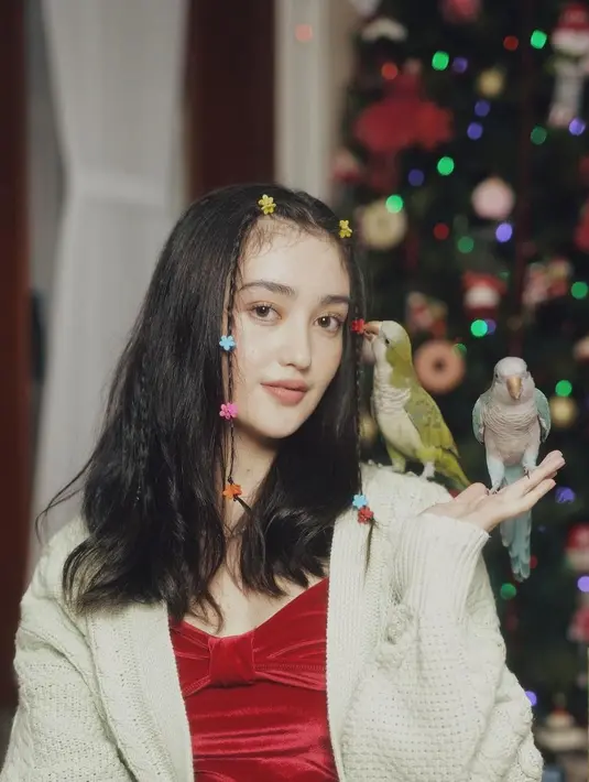 Ranty Maria berpose gemas dengan burung peliharaannya. Rambut bagian depannya diambil sedikit dan dikepang kecil-kecil, kemudian diberi jepit-jepit kecil berwarna-warni. Foto: Instagram.