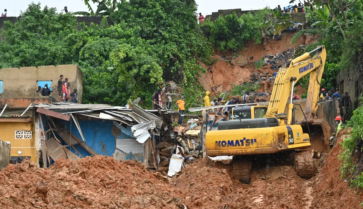 Tim penyelamat menggunakan alat berat mencari korban setelah rumah runtuh setelah hujan lebat di distrik Attecoube di Abidja, Pantai Gading (16/6/2022). Tanah longsor selama musim hujan adalah risiko yang terkenal buruk di Abidjan, kota yang berkembang pesat berpenduduk lima juta orang. (AFP/Issouf Sanogo)