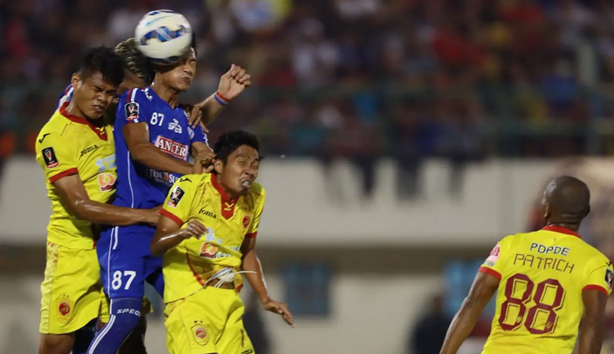 Bek Arema Cronus, Ahmad Alfarizi melakukan duel udara dengan pemain Sriwijaya FC pada laga semi final Piala Presiden di Stadion Manahan, Solo, Minggu (11/10/2015). Sriwijaya menang 2-1. (Bola.com/Nicklas Hanoatubun)