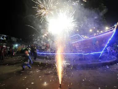 Warga menyalakan kembang api saat merayakan malam Idul Fitri 1443 Hijriah di kawasan Manggarai, Jakarta, Minggu (1/5/2022). Kemeriahan malam takbir di kawasan tersebut tak terbendung digelar sangat antusias oleh warga setelah sempat dilarang selama dua tahun akibat pandemi. (merdeka.com/Iqbal S. Nugroho)