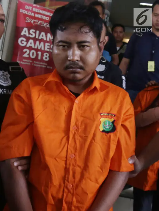 Pelaku pembunuhan wartawan Abdullah Fitri Setiawan yang tewas dalam drum M Nurhadi digiring petugas di Bogor di Polda Metro Jaya, Jakarta, Rabu (21/11). Kedua pelaku dijerat pasal pembunuhan berencana dan terancam hukuman mati. (Merdeka.com/Imam Buhori)