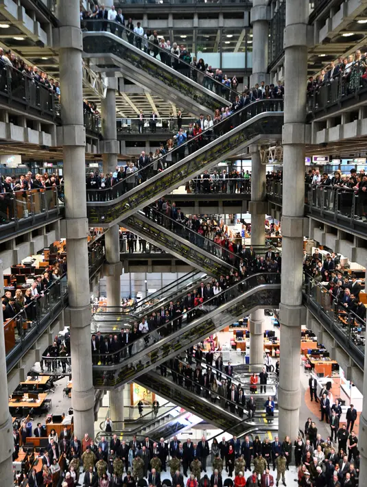 Karyawan mengheningkan cipta selama satu menit untuk memperingati Remembrance Day atau Hari Peringatan di Lloyds of London, Inggris, Jumat (12/11/2021). Remembrance Day adalah hari untuk mengenang jasa para tentara dan pihak-pihak yang berkorban pada Perang Dunia I. (DANIEL LEAL-OLIVAS/AFP)