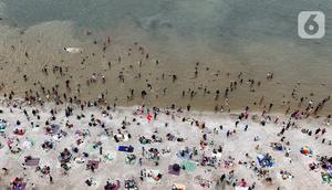 Libur perayaan Hari Raya Idul Fitri 1446 Hijriah atau Lebaran 2025 dimanfaatkan warga untuk berwisata ke sejumlah tempat, salah satunya Pantai Ancol Taman Impian, Jakarta. (Liputan6.com/Herman Zakharia)