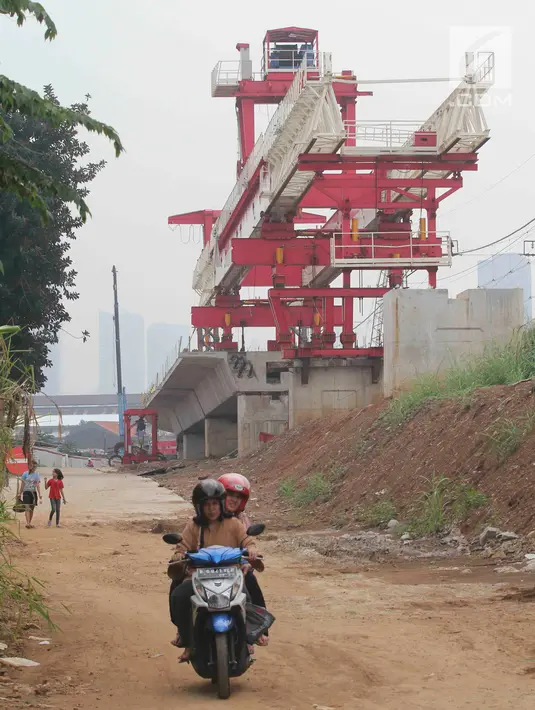Warga melintas di dekat konstruksi bangunan double-double track (DDT) Manggarai-Cikarang yang masih dalam tahap penyelesaian di kawasan Manggarai, Jakarta, Sabtu (15/7). (Liputan6.com/Angga Yuniar)