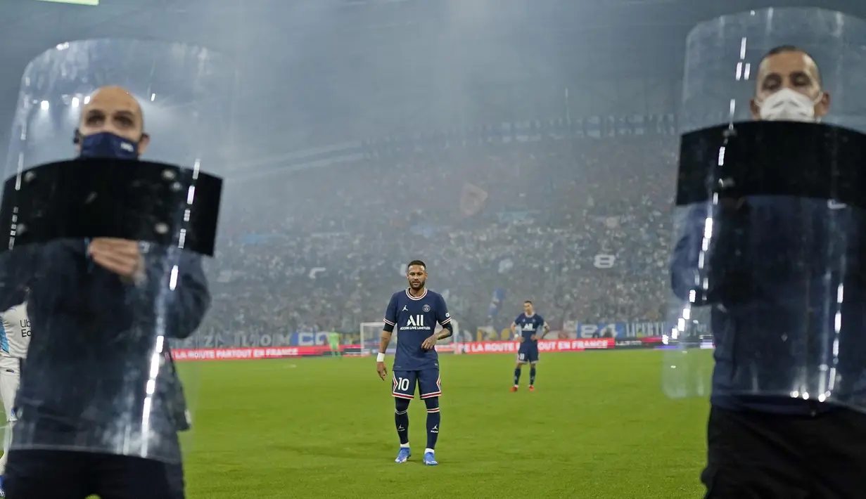 Pada laga PSG bertandang ke markas Marseille, Neymar mendapat penjagaan ketat petugas keamanan lengkap dengan tameng saat akan mengambil sepak pojok. (AP Photo/Daniel Cole)