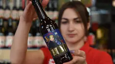 Karyawan menunjukkan botol bir bergambar Presiden AS Donald Trump di perusahaan bir Pravada di Lviv, Ukraina, 20 Mei 2017. Perusahaan itu menciptakan bir yang dijuluki sebagai 'Trump. The President of the Divided States of America'. (Yuri DYACHYSHYN/AFP)