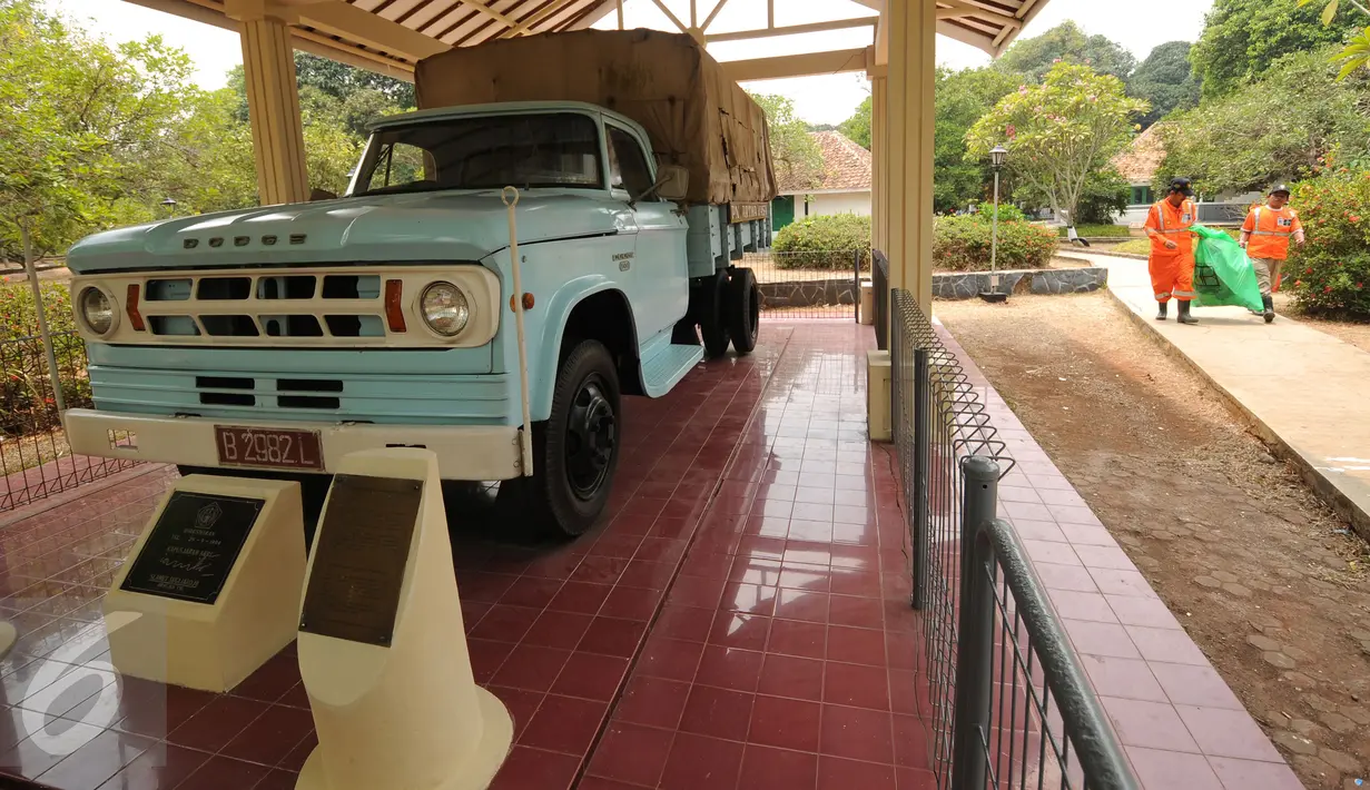 Petugas kebersihan melintas di sisi replika mobil pengangkut yang pernah digunakan PKI saat melakukan pemberontakan di Monumen Pancasila Sakti, Jakarta, Selasa (29/9/2015). (Liputan6.com/Helmi Fithriansyah)