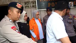 Tersangka Ratna Sarumpaet digiring petugas keluar ruang tahanan di Polda Metro Jaya, Jakarta, Rabu (10/10). Tersangka penyebar berita bohong atau hoax itu keluar tahanan untuk periksa kesehatan di Biddokkes. (Liputan6.com/Johan Tallo)