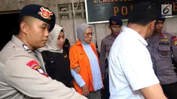 Tersangka Ratna Sarumpaet digiring petugas keluar ruang tahanan di Polda Metro Jaya, Jakarta, Rabu (10/10). Tersangka penyebar berita bohong atau hoax itu keluar tahanan untuk periksa kesehatan di Biddokkes. (Liputan6.com/Johan Tallo)