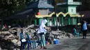 Seorang anak yang terkena dampak gempa meminta sumbangan pada pengguna jalan yang melintas di Donggala, Sulawesi Tengah, Jumat (5/10). Akibat terlambatnya pasokan bantuan, mereka terpaksa meminta sumbangan hingga turun ke jalan. (AFP PHOTO / Jewel SAMAD)