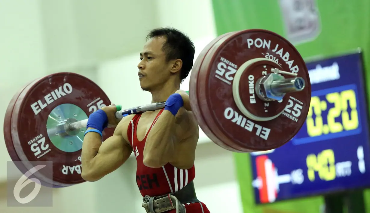 Lifter Nanggroe Aceh Darussalam, Surahmat saat melakukan angkatan clean and jerk di kelas 56kg PON XIX Jabar di Gymnasium Si Jalak Harupat, Kab Bandung, Selasa (20/9). Surahmat meraih emas dengan total angkatan 255kg. (Liputan6.com/Helmi Fithriansyah)