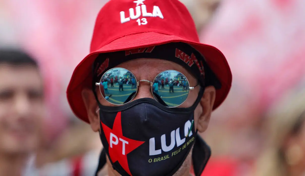 Seorang pendukung mantan presiden Brasil (2003-2010) dan calon presiden dari Partai Buruh (PT) berhaluan kiri, Luiz Inacio Lula da Silva, menghadiri rapat umum kampanye di Sao Mateus, Negara Bagian Sao Paulo, Brasil, Senin (17/10/2022). Lula da Silva dan presiden Jair Bolsonaro akan menghadapi putaran kedua pemilihan presiden pada 30 Oktober, dengan ekspektasi persaingan ketat mendorong kedua belah pihak untuk mengintensifkan kampanye menjelang pemilihan. (Miguel SCHINCARIOL / AFP)