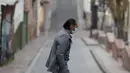 Pejalan kaki yang mengenakan masker menyeberang jalan di tengah lockdown yang diberlakukan kembali di Bogota, Kolombia, Sabtu (10/4/2021). Walikota Bogota Claudia Lopez memerintahkan lockdown hingga 13 April saat ibu kota mengalami peningkatan tajam infeksi COVID- 19. (AP Photo/Fernando Vergara)