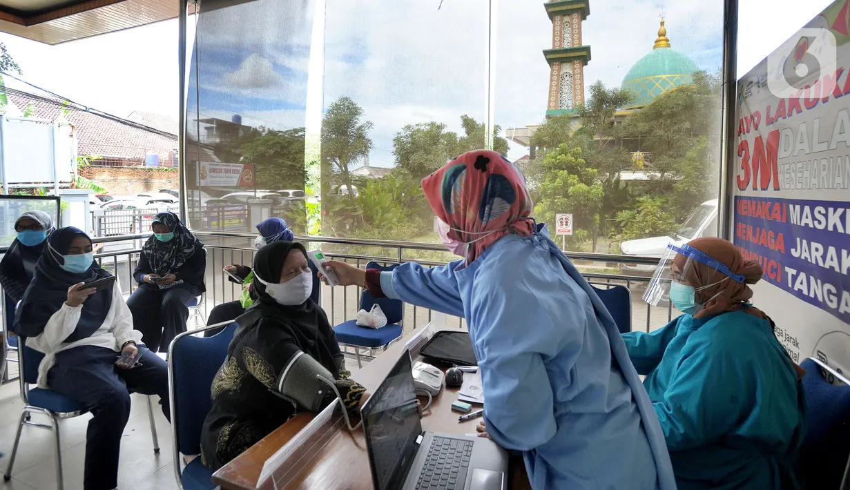Petugas mengecek suhu tubuh tenaga kesehatan berusia lanjut sebelum menerima suntikan vaksin COVID-19 Sinovac di Puskesmas Kecamatan Jagakarsa, Jakarta, Kamis (11/2/2021). Sekitar 11 ribu nakes lansia berusia di atas 60 tahun menjadi prioritas penerima vaksin covid-19. (merdeka.com/Arie Basuki)