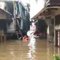 Seorang Warga Berenang Untuk Membagikan Makanan Bagi Korban Banjir di Kebon Pala, Jakarta Timur, Rabu (1/1/2020). (Foto: Nanda Perdana Putra/Liputan6.com)