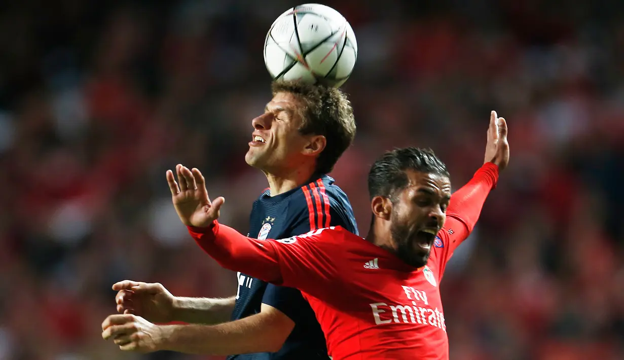 Penyerang Muenchen, Thomas Muller (kiri) berebut bola udara dengan gelandang Benfica, Mehdi Carcela Gonzalez di leg kedua Liga Champions di Stadion Da Luz, Lisboa, Portugal, Kamis (14/4). (Reuters/Rafael Marchante)
