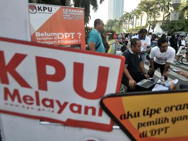 Petugas KPU DKI membuka stan pendaftaran daftar pemilih tetap (DPT) di kawasan Car Free Day, Jakarta, Minggu (21/10). Pendaftaran ini dibuka hingga 28 Oktober dengan syarat membawa fotocopy e-KTP dan Kartu Keluarga. (Merdeka.com/Iqbal S. Nugroho)