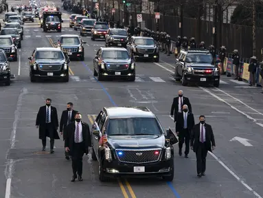 Mobil Presiden Amerika Serikat (AS), Joe Biden dalam pengawalan melintas di 15th street menuju Gedung Putih di Washington, Rabu (20/1/2020). Joe Biden menggunakan mobil dinas yang sama dengan yang digunakan oleh Presiden sebelumnya, Donald Trump yaitu Cadillac One. (Jose Luis Magana/POOL/AFP)