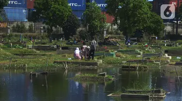 Warga berdoa saat ziarah kubur pada hari kedua Idul Fitri 1441 Hijriah di Tempat Pemakaman Umum (TPU) Semper, Jakarta, Senin (25/5/2020). Di tengah pandemi Covid-19,  peziarah kubur di TPU Semper berkurang. (merdeka.com/Imam Buhori)