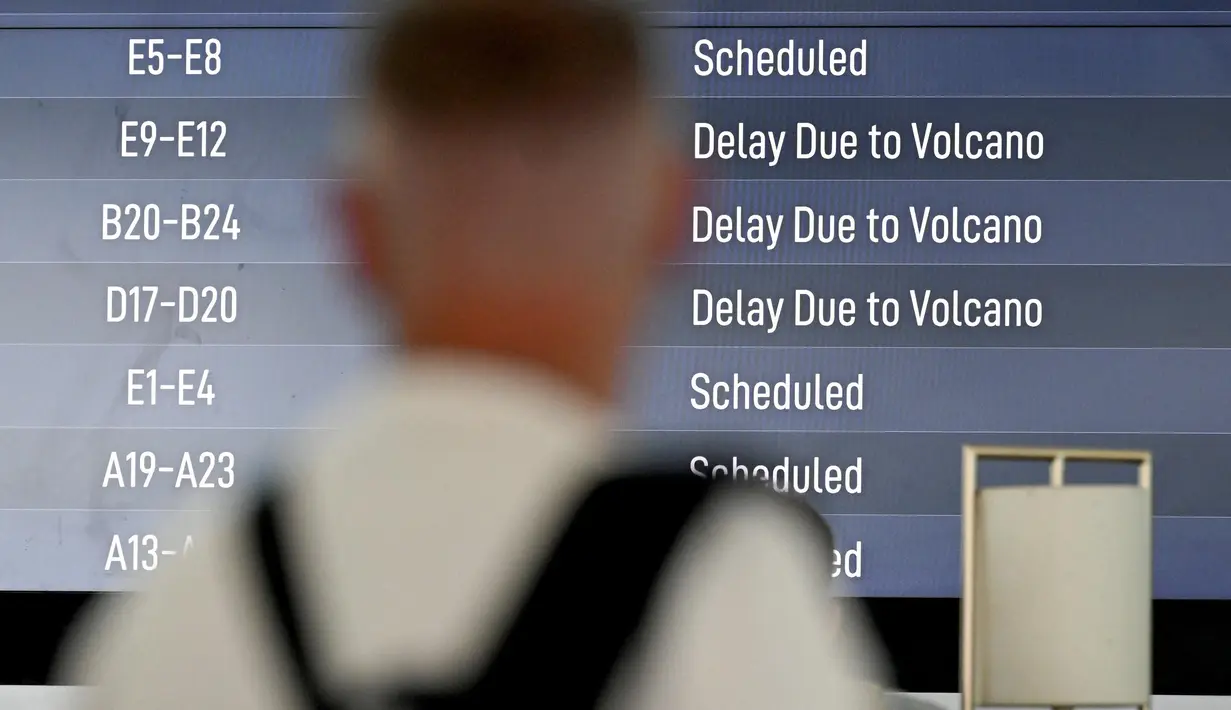 Salah satu calon penumpang melihat papan elektronik yang menampilkan penerbangan yang dibatalkan di Bandara Internasional Ngurah Rai, Tuban, dekat Denpasar, Bali, pada 21 Maret 2025. (SONNY TUMBELAKA/AFP)
