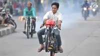 Seorang pembalap mengangkat sepeda motornya saat ikut dalam balapan liar di Jakarta, Minggu (27/5) pagi. Mereka memanfaatkan sepinya arus lalu lintas kendaraan untuk balapan liar. (Merdeka.com/Iqbal S Nugroho)