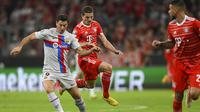 Pemain Barcelona, Robert Lewandowski (kiri) berebut bola dengan pemain Bayern Munchen, Marcel Sabitzer pada pertandingan grup C Liga Champions di Allianz Arena di Munich, Jerman, Rabu, (13/9/2022) dini hari WIB. (AP Photo/Andreas Schaad)