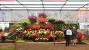 Orang-orang melihat pajangan bunga selama RHS Chelsea Flower Show 2021 di London pada Senin (20/9/2021). Pertunjukan bunga Chelsea sempat ditunda dari tanggal musim semi biasanya karena pembatasan penguncian di tengah penyebaran pandemi COVID-19. (JUSTIN TALLIS/AFP)