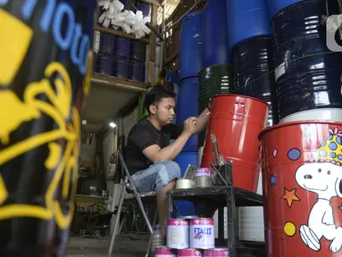 Faiz (21) melukis tong sampah dengan gambar tokoh kartun di Setu, Tangerang Selatan, Banten, Kamis (1/10/2020). Faiz mengecat ulang tong bekas dan melukisnya dengan tokoh-tokoh kartun, lalu menjualnya dengan harga Rp 85 hingga 120 ribu per unit. (merdeka.com/Dwi Narwoko)