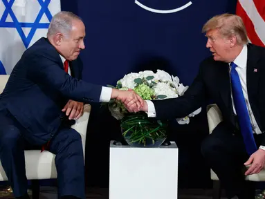 Presiden AS Donald Trump berjabat tangan dengan Perdana Menteri Israel Benjamin Netanyahu saat bertemu di sela Forum Ekonomi Dunia, Davos (25/1). (AP Photo / Evan Vucci)