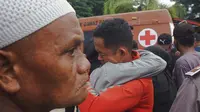 Seorang pria berpelukan sambil menangis setelah gempa bumi di Mamuju, Sulawesi Barat, Indonesia, Jumat (15/1/2021). Gempa ini menyebabkan kerusakan parah pada Hotel Maleo, kantor Gubernur Sulbar, serta RSUD Mamuju. (AP Photo/Azhari Surahman)