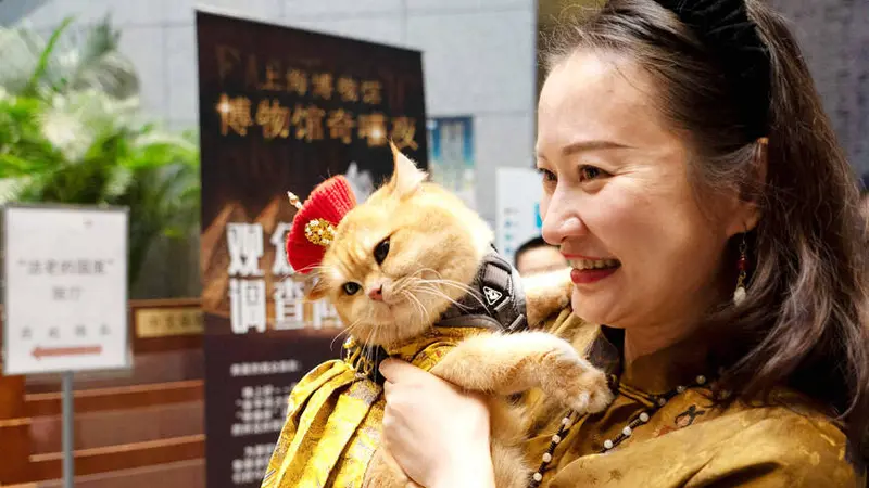 Salah satu pengunjung menggendong kucing peliharaannya yang diberi nama Trump dalam acara di Museum Shanghai. (Foto. AFP)