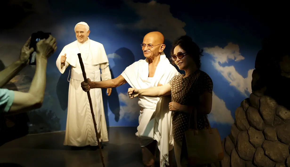 Seorang wanita berselfie disamping patung lilin Mahatma Gandhi (tengah) dan Paus Francis (kiri) di Grevin Wax Museum, Korea Selatan, Kamis (30/7/2015). Sekitar 80 tokoh dunia ditampilkan dalam meseum tersebut. (REUTERS/Kim Hong-Ji)