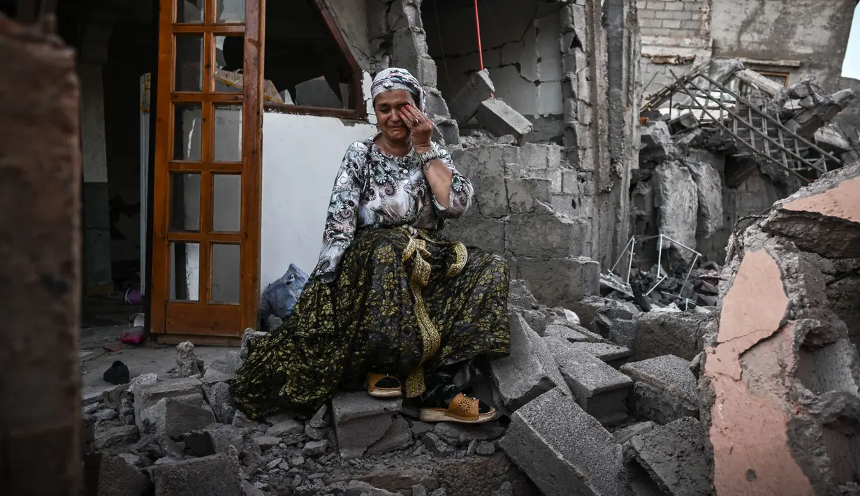Seorang, yang selamat dari gempa mematikan berkekuatan 6,8 skala Richter pada 8 September, menangis saat dia duduk di reruntuhan rumahnya yang rusak, di desa pegunungan Moulay Brahim di provinsi al-Haouz di Maroko tengah pada 10 September 2023. (Photo by Philippe LOPEZ / AFP)