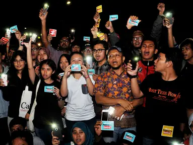 Sejumlah aktivis menyalakan senter saat melakukan aksi solidaritas #MelawanGelap di depan Istana Merdeka, Jakarta, Jumat (5/8). Aksi tersebut merupakan bentuk dukungan kepada Koordinator Kontras Haris Azhar. (Liputan6.com/Gempur M Surya)