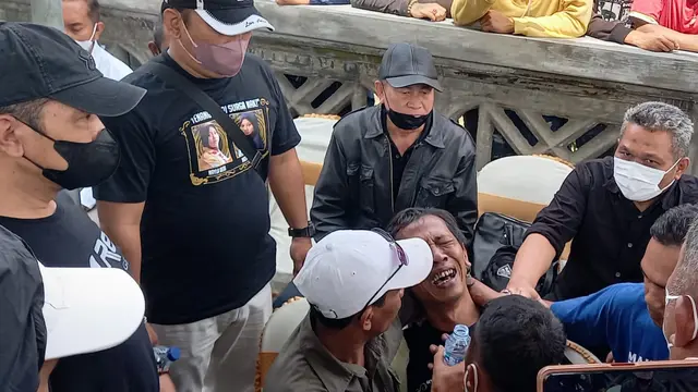 Devi Athok, ayah korban Kanjuruhan menangis saat datang di lokasi autopsi jenasah kedua anaknya di TPU Pathuk, Wajak, Malang, pada Sabtu, 5 November 2022. (Zainul/Liputan6.com)
