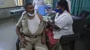 Petugas kesehatan memberikan dosis ketiga vaksin COVID-19 kepada polisi di pusat rumah sakit polisi pemerintah di Hyderabad, India (10/1/2022). India melaporkan 179.723 kasus baru pada Senin (10/1), sebagian besar berada di kota-kota terbesar Delhi, Mumbai dan Kalkuta. (AP Photo/Mahesh Kumar A.)