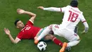 Aksi pemain Maroko, Younes Belhanda (kiri) saat berebut bola dengan pemain Iran, Alireza Jahanbakhsh pada  laga grup B Piala Dunia 2018  di St. Petersburg Stadium, Rusia, (15/6/2018). Iran menang 1-0. (AP/Darko Vojinovic)