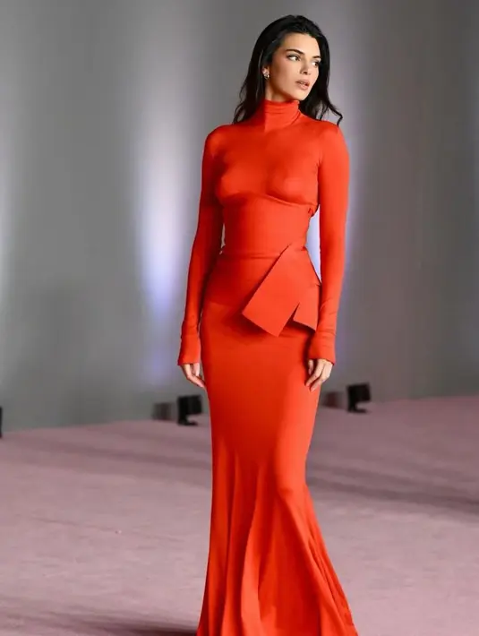 Kendall tampil dalam balutan gaun Fendi Couture semi-tipis berwarna merah, berlengan panjang, bergaya halterneck. [@kendalljenner]