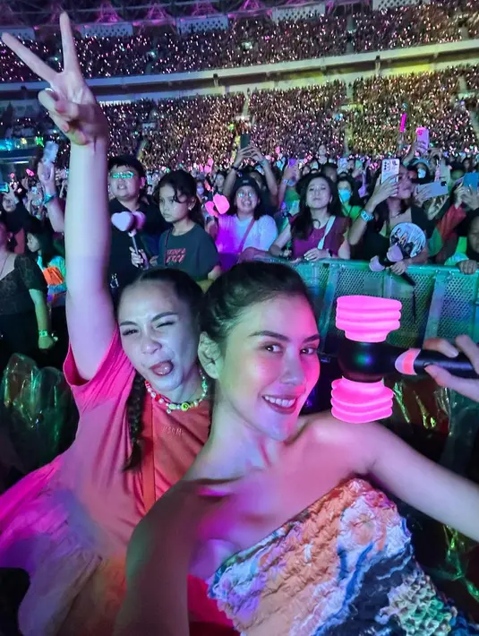Syahnaz kompak nonton konser bareng Gigi. Syahnaz bak remaja mengenakan strapless top bermotif tie-dye, sedangkan Gigi mengenakan atasan lengan pendek berwarna pink. Foto: Instagram.