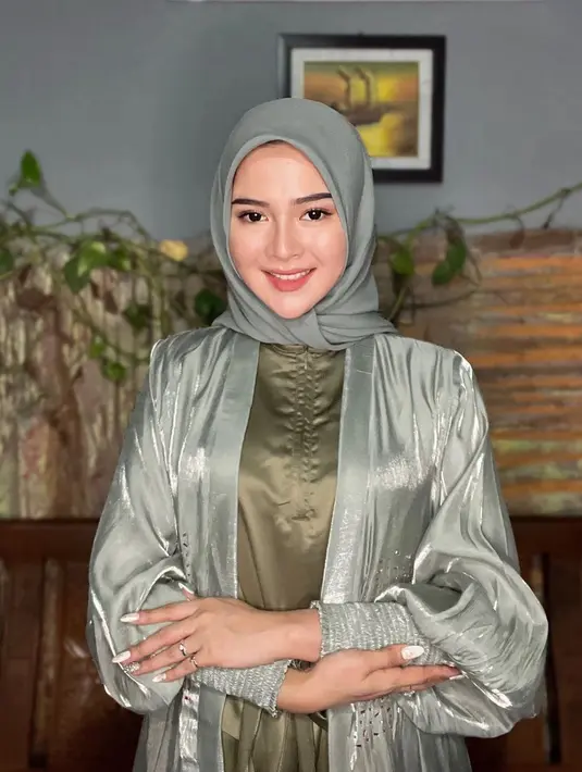 Ia menyempurnakan penampilannya dengan hijab warna hijau sage. Wajahnya pun dipoles dengan makeup natural.
