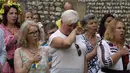 Pengungsi Ukraina bereaksi saat lagu kebangsaan dimainkan dalam perayaan Hari Kemerdekaan Ukraina di Chichester, Inggris selatan, Sabtu, 27 Agustus 2022. Chichester dinobatkan sebagai daerah paling dermawan di negara itu untuk menampung pengungsi Ukraina. (AP Photo/Frank Augstein)